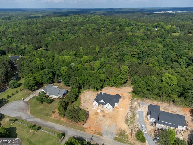 aerial view of property and surrounding area featuring a heavily wooded area