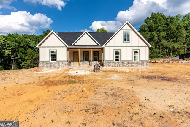 modern farmhouse with a porch and board and batten siding