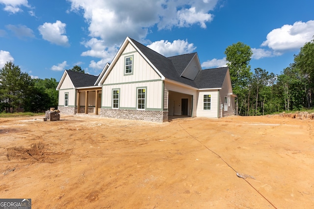 modern inspired farmhouse featuring board and batten siding and a shingled roof