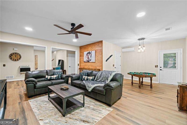 living area featuring light wood finished floors, ceiling fan, heating unit, recessed lighting, and an AC wall unit