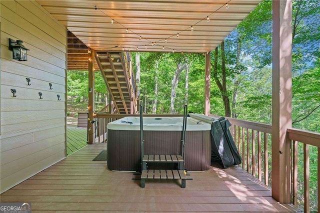 deck with a hot tub and stairway