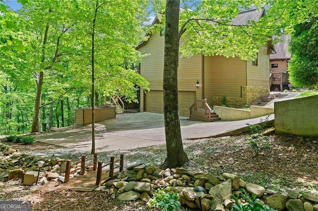 view of side of home with concrete driveway and a garage