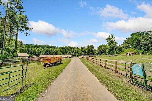 view of asphalt road featuring a rural view and an exterior structure