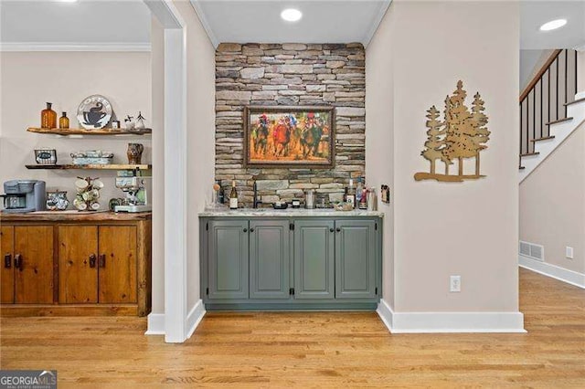 bar area with ornamental molding, light wood-style floors, stairway, recessed lighting, and baseboards