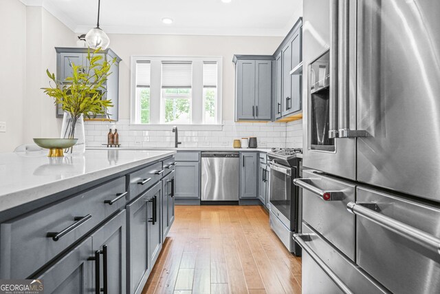 2744 Bell Dr SE, Smyrna, GA 30080 - kitchen featuring appliances with stainless steel finishes, gray cabinets, decorative backsplash, light wood finished floors, and crown molding