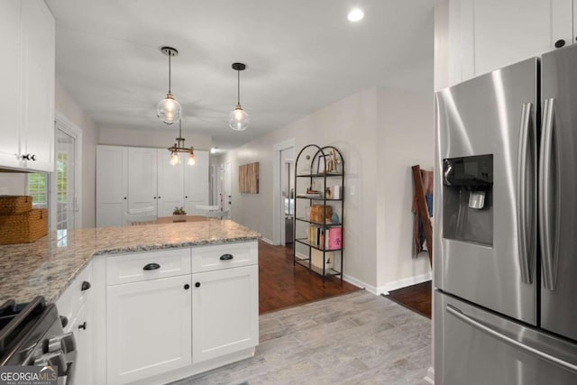 283 Norton Cir SE, Smyrna, GA 30082 - kitchen with appliances with stainless steel finishes, a peninsula, white cabinets, light stone counters, and recessed lighting