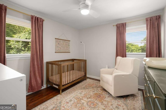 283 Norton Cir SE, Smyrna, GA 30082 - bedroom with wood finished floors, a crib, multiple windows, and baseboards
