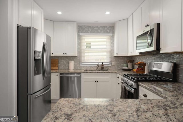 283 Norton Cir SE, Smyrna, GA 30082 - kitchen with appliances with stainless steel finishes, a sink, light stone counters, tasteful backsplash, and recessed lighting