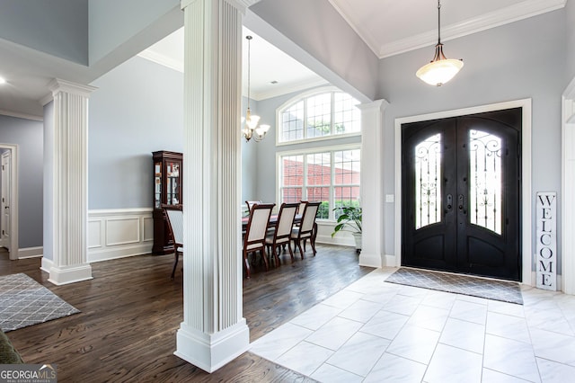 1365 Ivy Plantation, Monroe, GA 30656 - entryway featuring decorative columns, ornamental molding, a towering ceiling, a chandelier, and wood finished floors