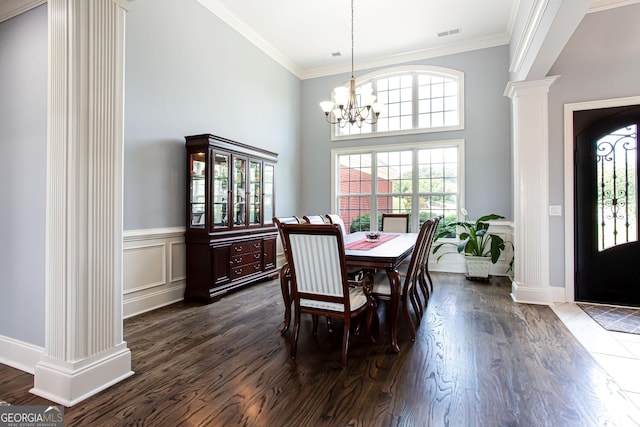 1365 Ivy Plantation, Monroe, GA 30656 - dining space with ornate columns, crown molding, dark wood-type flooring, a high ceiling, and a chandelier