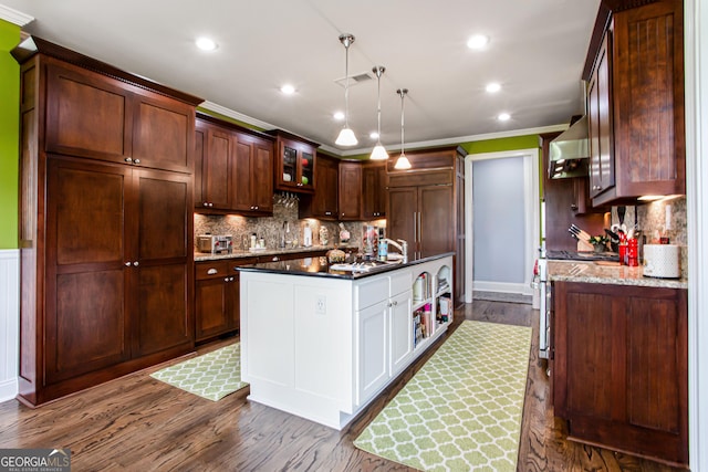 1365 Ivy Plantation, Monroe, GA 30656 - kitchen with a center island with sink, wall chimney range hood, dark wood-type flooring, ornamental molding, and tasteful backsplash