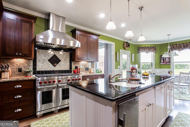 1365 Ivy Plantation, Monroe, GA 30656 - kitchen with range with two ovens, wall chimney exhaust hood, wine cooler, a sink, and wood finished floors