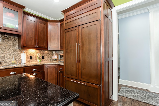 1365 Ivy Plantation, Monroe, GA 30656 - kitchen with crown molding, backsplash, dark stone counters, baseboards, and glass insert cabinets