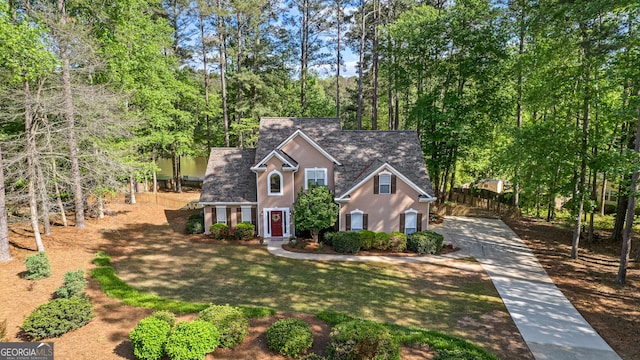 226 Le Paradis Blvd, Sharpsburg, GA 30277 - traditional-style house featuring stucco siding, a front lawn, view of scattered trees, and driveway