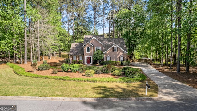 226 Le Paradis Blvd, Sharpsburg, GA 30277 - traditional-style house featuring concrete driveway, stucco siding, a front lawn, and view of wooded area