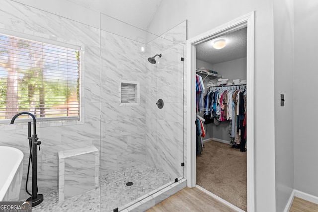 226 Le Paradis Blvd, Sharpsburg, GA 30277 - full bathroom featuring a stall shower, a spacious closet, a freestanding bath, baseboards, and a textured ceiling