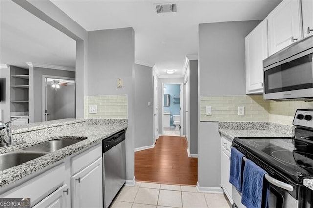 3655 Habersham Rd NE Unit 244B, Atlanta, GA 30305 - kitchen with stainless steel appliances, white cabinets, ornamental molding, light tile patterned floors, and ceiling fan