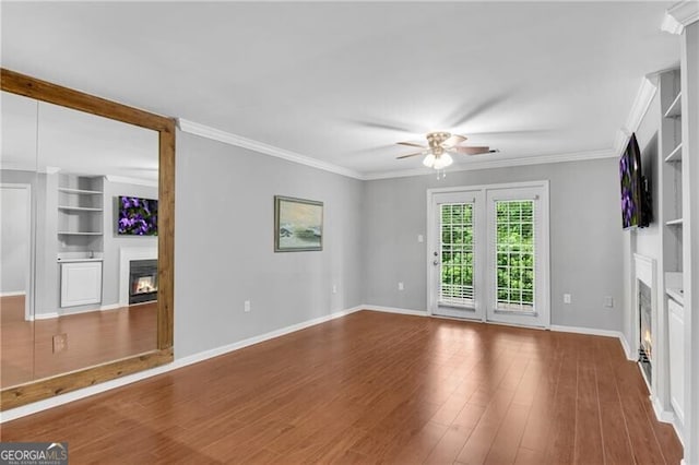 3655 Habersham Rd NE Unit 244B, Atlanta, GA 30305 - empty room with a glass covered fireplace, a ceiling fan, built in shelves, baseboards, and wood finished floors