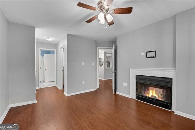 3655 Habersham Rd NE Unit 244B, Atlanta, GA 30305 - unfurnished living room with a tile fireplace, ceiling fan, wood finished floors, and baseboards