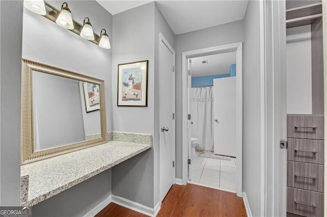 3655 Habersham Rd NE Unit 244B, Atlanta, GA 30305 - bathroom featuring toilet, wood finished floors, vanity, and baseboards