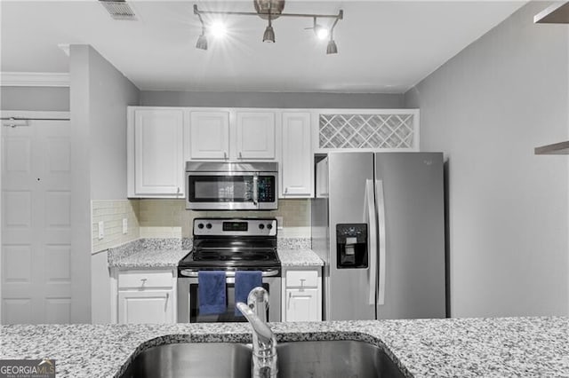 3655 Habersham Rd NE Unit 244B, Atlanta, GA 30305 - kitchen with stainless steel appliances, white cabinetry, light stone countertops, and backsplash