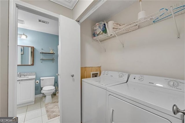 clothes washing area featuring separate washer and dryer and light tile patterned floors