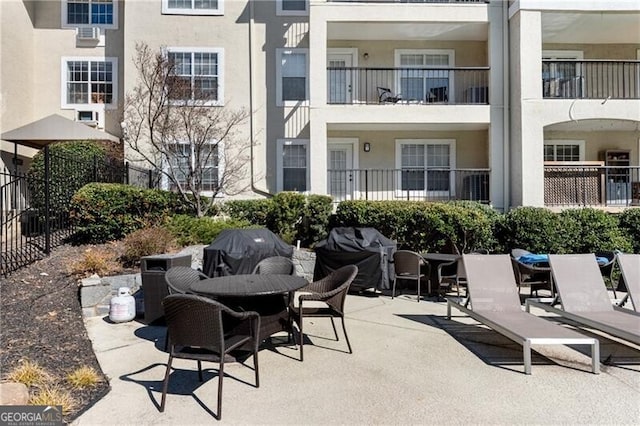 view of patio with outdoor dining area, a grill, and fence