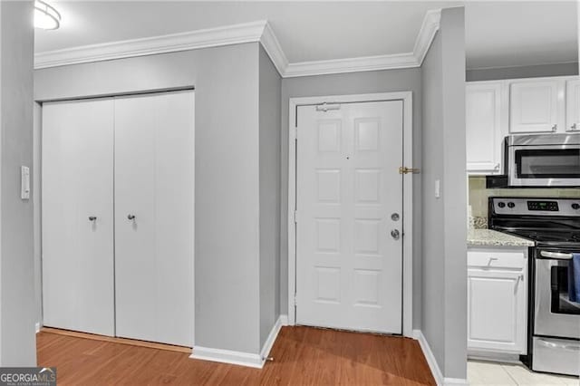 3655 Habersham Rd NE Unit 244B, Atlanta, GA 30305 - kitchen featuring appliances with stainless steel finishes, ornamental molding, white cabinetry, baseboards, and light wood-style floors