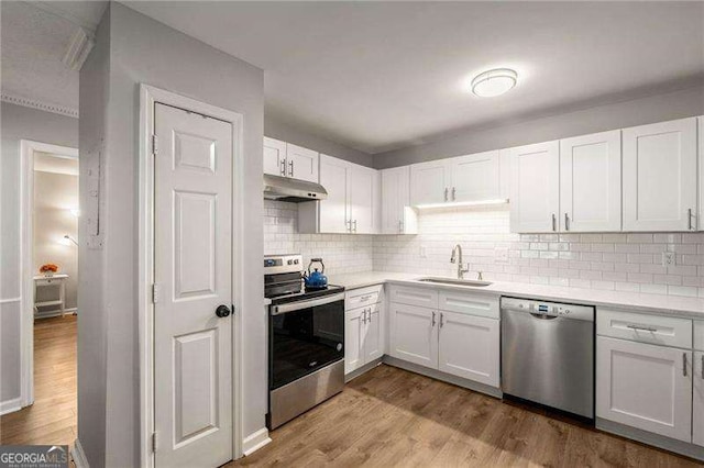 1140 Moorestown Cir, Decatur, GA 30033 - kitchen featuring stainless steel appliances, a sink, under cabinet range hood, light countertops, and wood finished floors