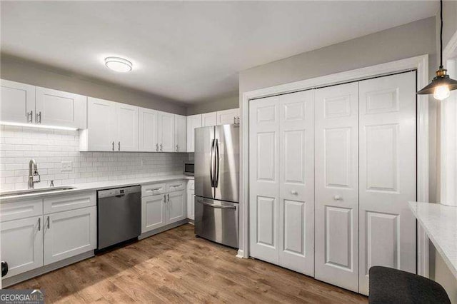1140 Moorestown Cir, Decatur, GA 30033 - kitchen featuring stainless steel appliances, a sink, light countertops, decorative backsplash, and white cabinetry
