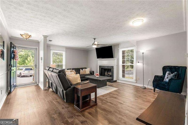 1140 Moorestown Cir, Decatur, GA 30033 - living room with ceiling fan, a textured ceiling, ornamental molding, wood finished floors, and a fireplace with raised hearth