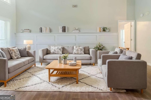 living area featuring wood finished floors and a decorative wall