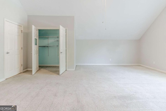 unfurnished bedroom featuring carpet floors, lofted ceiling, and baseboards