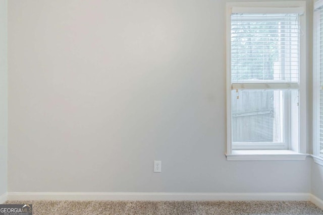 carpeted spare room featuring baseboards