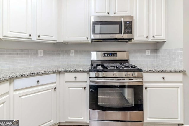 5335 Lexington View Pl, Sugar Hill, GA 30518 - kitchen featuring stainless steel appliances, white cabinetry, tasteful backsplash, and light stone countertops