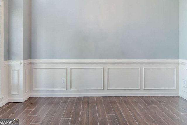 detailed view of a decorative wall, a wainscoted wall, and wood finished floors