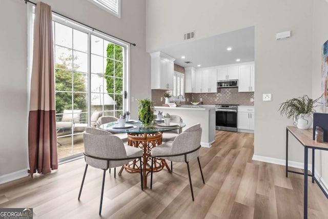 222 Harmony Ct, Alpharetta, GA 30004 - dining room featuring light wood-style flooring, a towering ceiling, baseboards, and recessed lighting