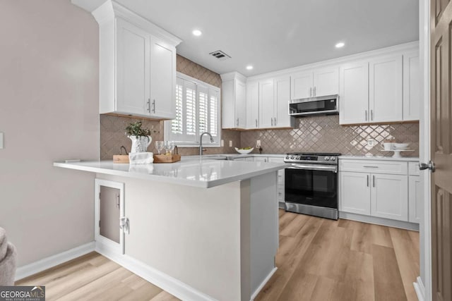 222 Harmony Ct, Alpharetta, GA 30004 - kitchen with stainless steel appliances, light wood-style floors, white cabinetry, light countertops, and a peninsula