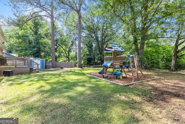 view of yard with a storage unit, a playground, an outbuilding, and view of scattered trees
