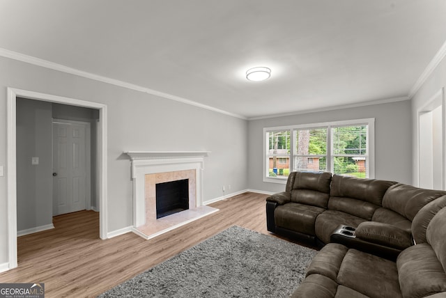 living room featuring ornamental molding, wood finished floors, baseboards, and a fireplace