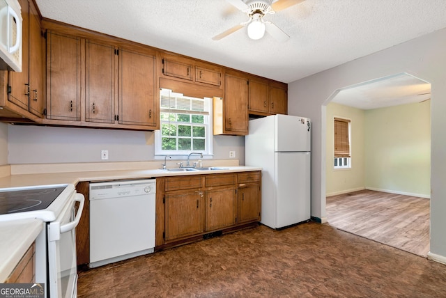 1405 Lumpkin County Pkwy, Dahlonega, GA 30533 - kitchen featuring white appliances, a sink, dark floors, brown cabinets, and a textured ceiling
