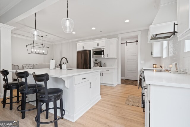 kitchen with stainless steel appliances, a sink, white cabinetry, crown molding, and recessed lighting