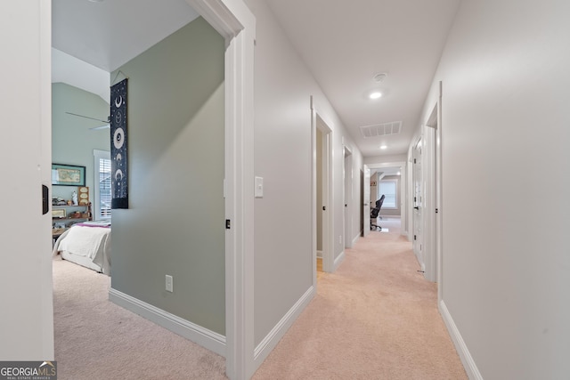 hallway with light colored carpet, recessed lighting, and baseboards