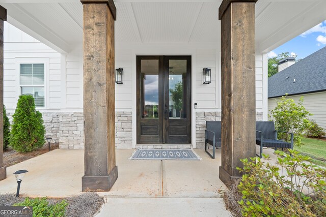 property entrance with french doors and stone siding
