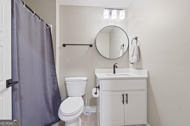 full bathroom featuring toilet, baseboards, vanity, and curtained shower