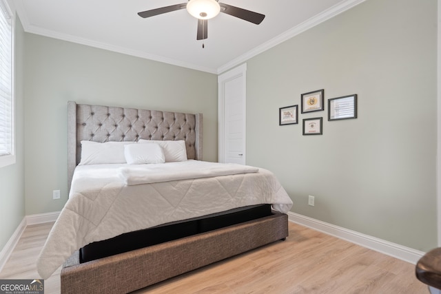 bedroom featuring crown molding, wood finished floors, baseboards, and ceiling fan