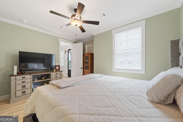 bedroom featuring ornamental molding, light wood-type flooring, ceiling fan, and baseboards