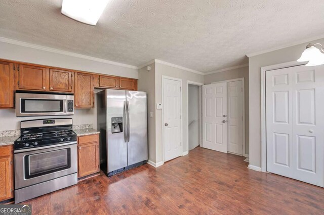 616 Lone Oak Ct, Lithonia, GA 30058 - kitchen featuring stainless steel appliances, brown cabinetry, dark wood-style floors, a textured ceiling, and crown molding