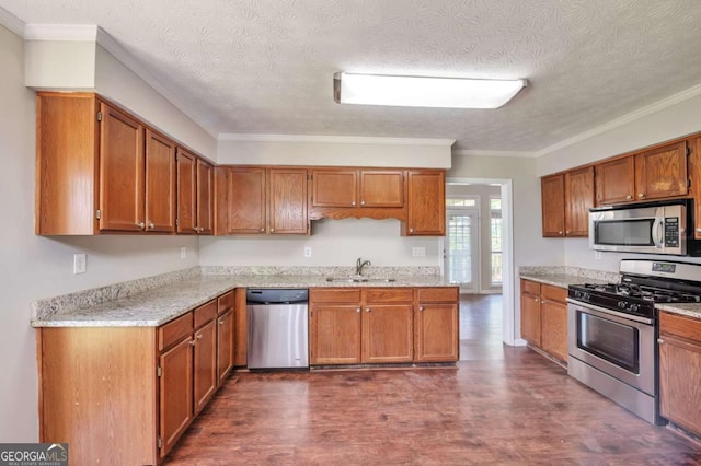 616 Lone Oak Ct, Lithonia, GA 30058 - kitchen featuring stainless steel appliances, dark wood finished floors, a sink, brown cabinets, and crown molding
