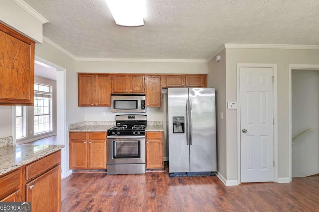 616 Lone Oak Ct, Lithonia, GA 30058 - kitchen with appliances with stainless steel finishes, brown cabinetry, dark wood-style floors, light stone counters, and ornamental molding